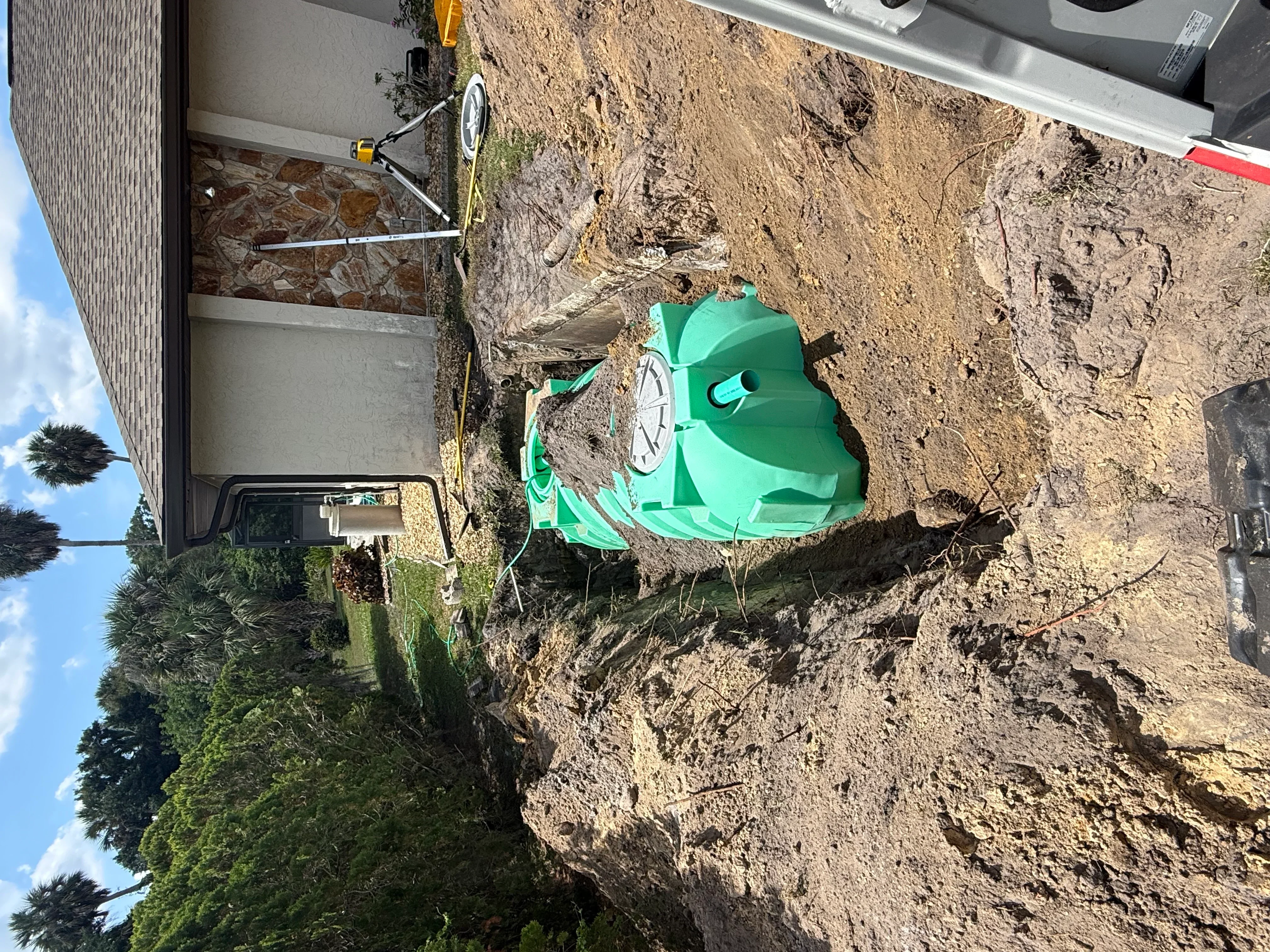 Green septic tank installed in excavated residential lot with proper grading
