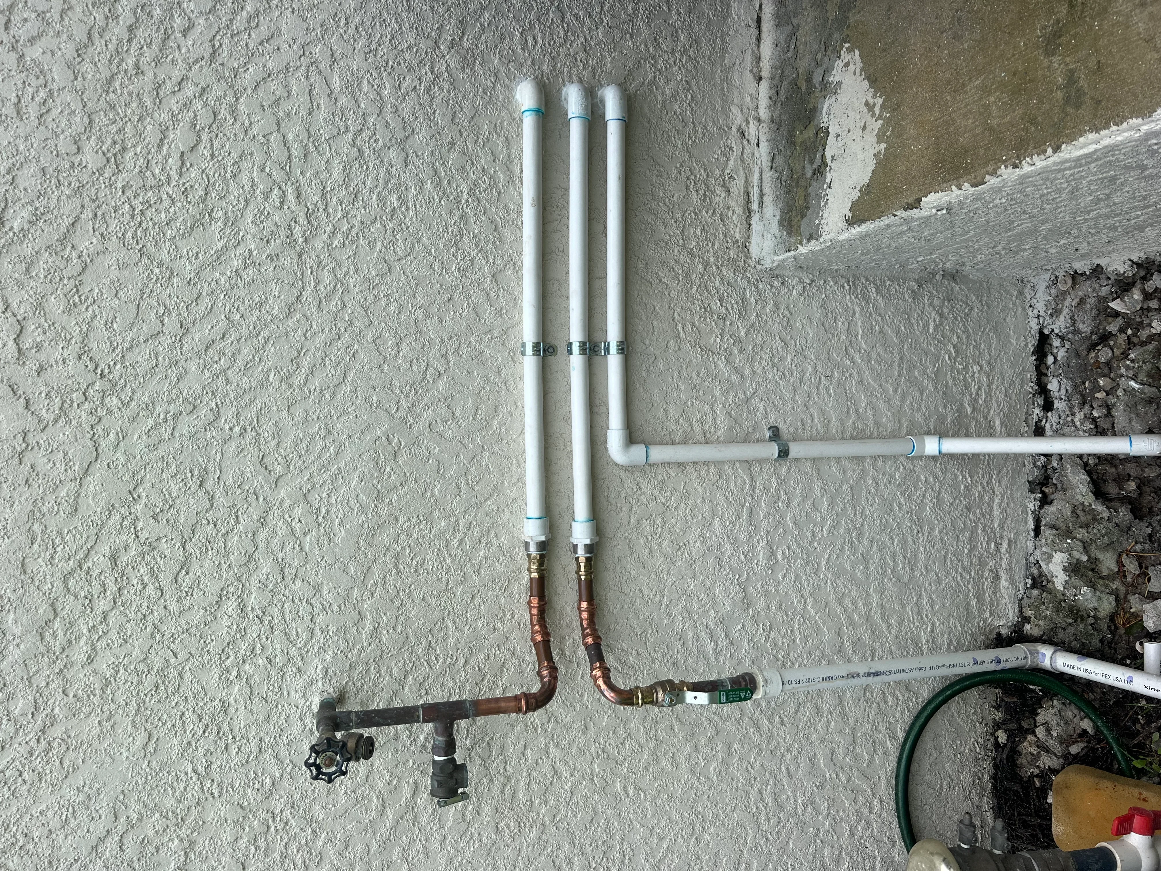 PEX water lines with copper manifold and shut-off valves installed on interior wall