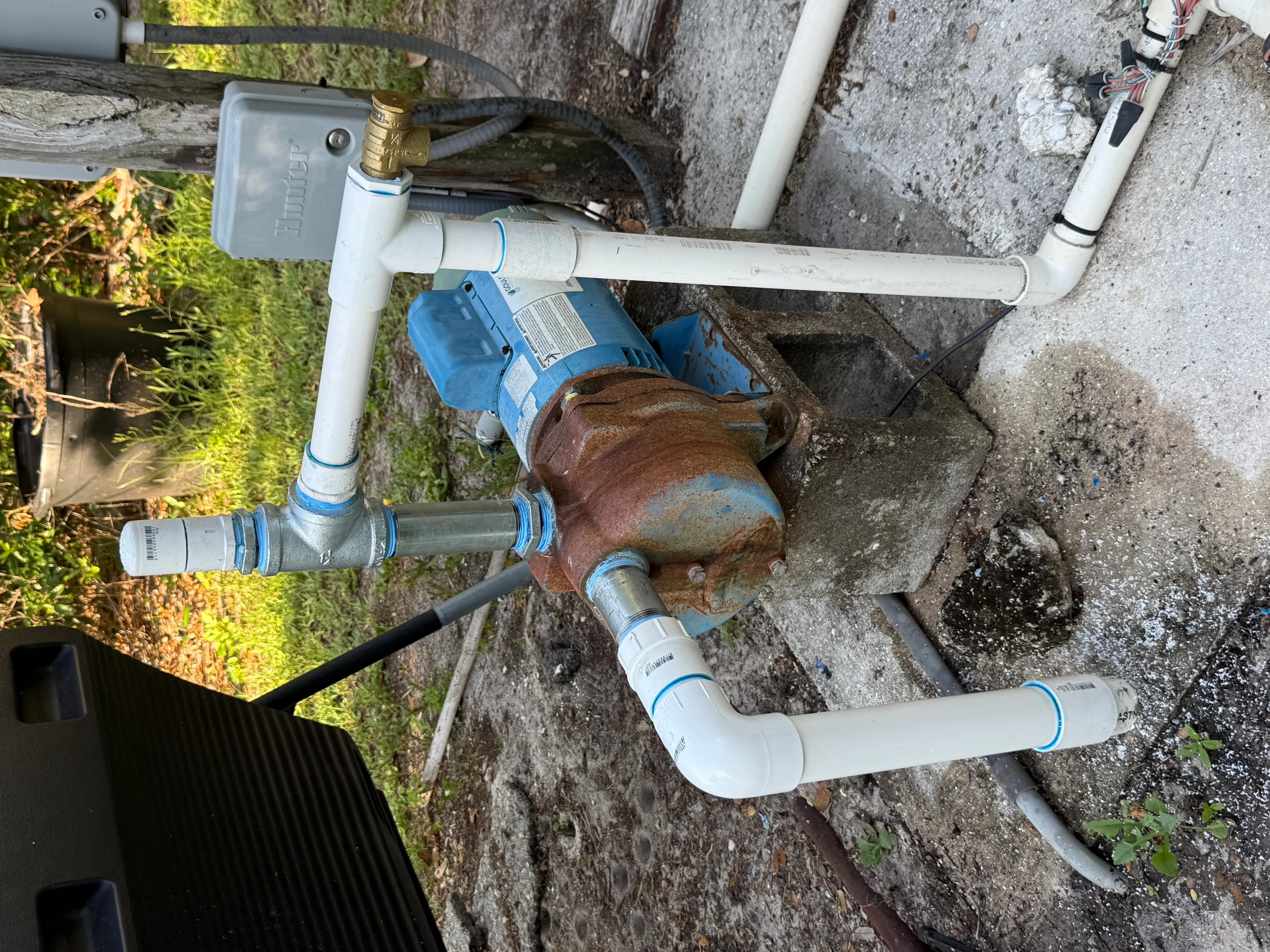 New PVC water meter installation with brass valve and white supply lines replacing corroded metal meter