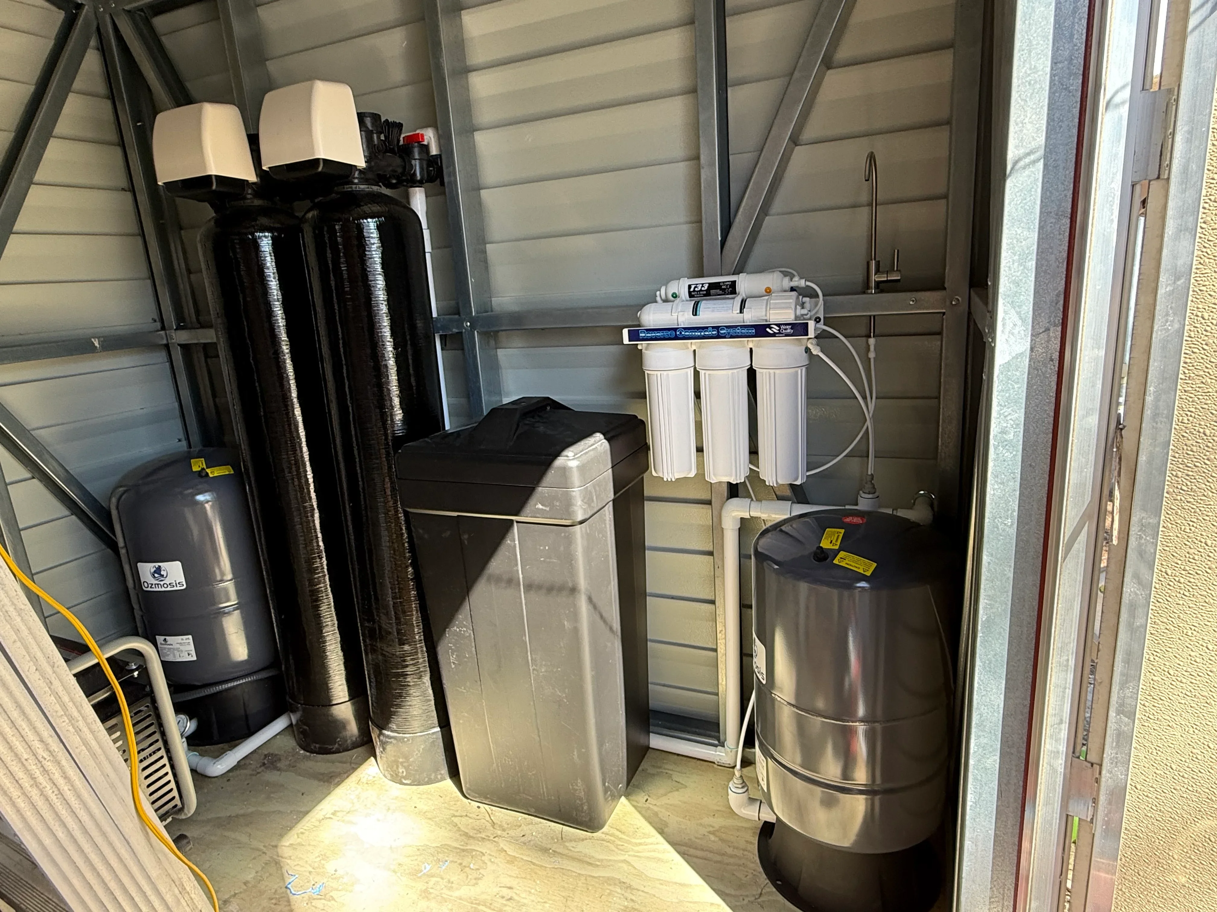 Water softener and reverse osmosis filtration system installed in utility room